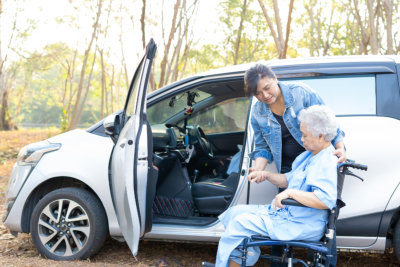 woman helping senior to the car