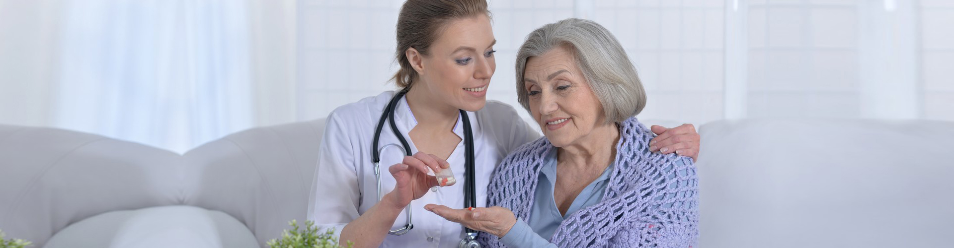 woman give elderly woman a medicine